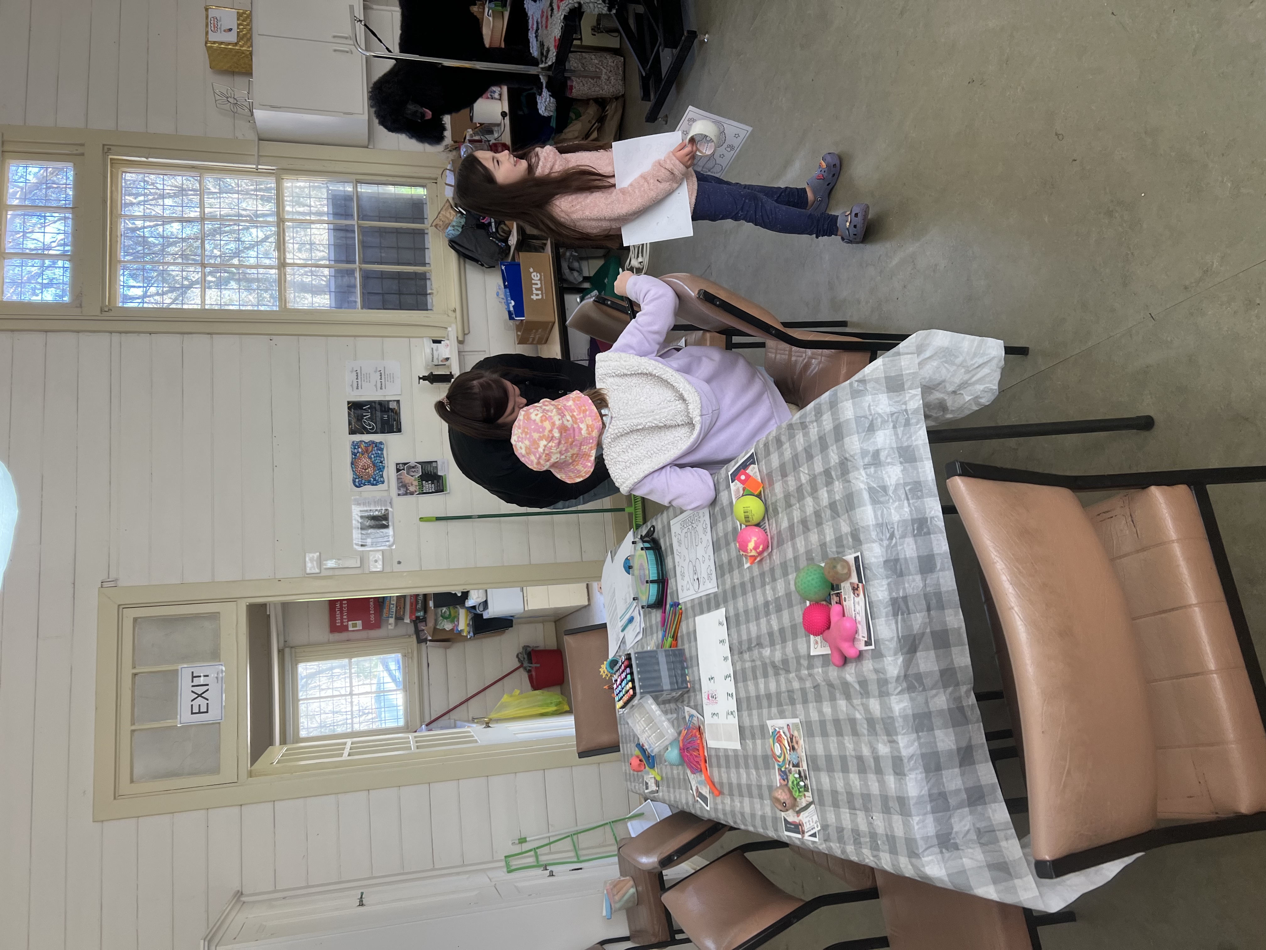 Children and a support person enjoying creative activities at the community hall